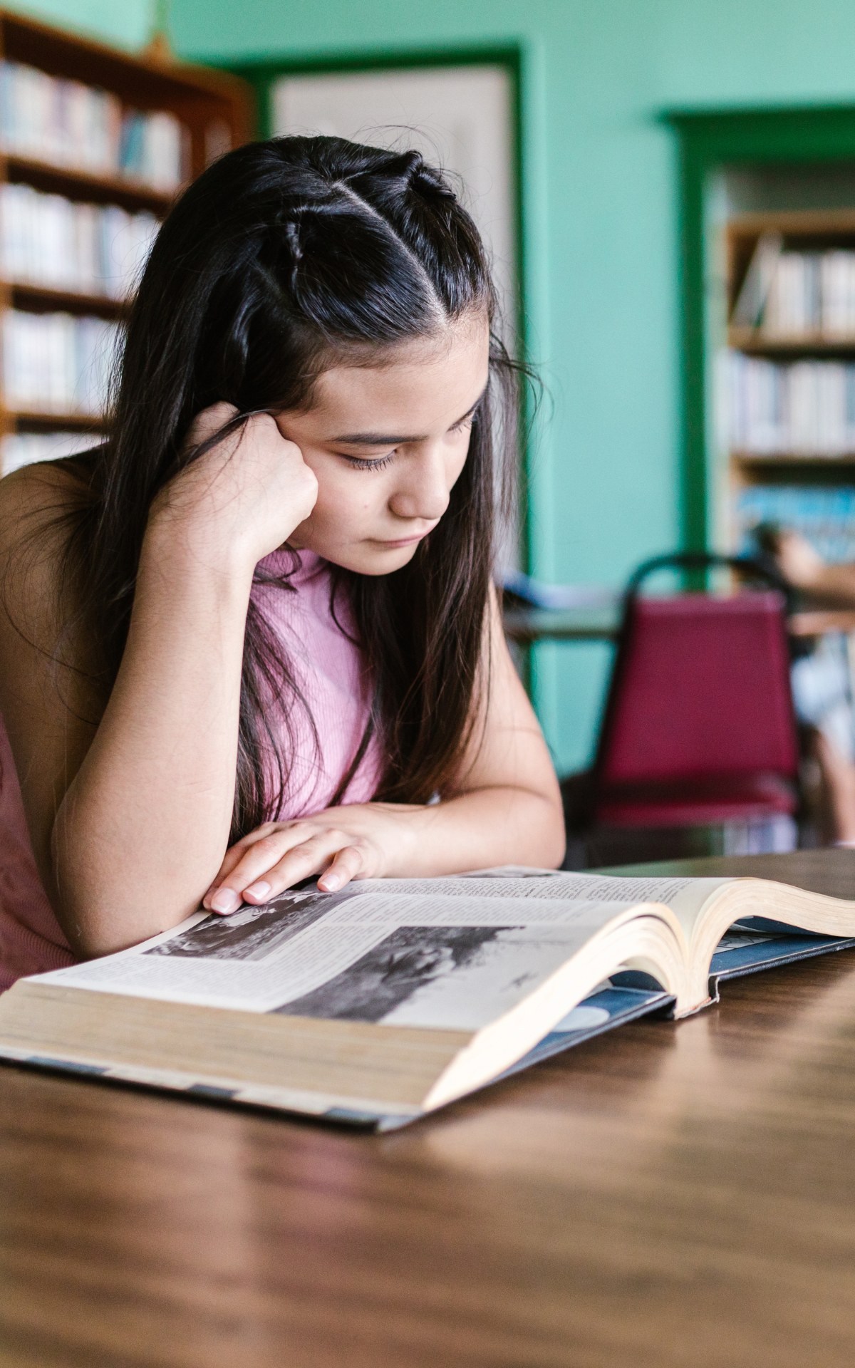 student reading a book in the library